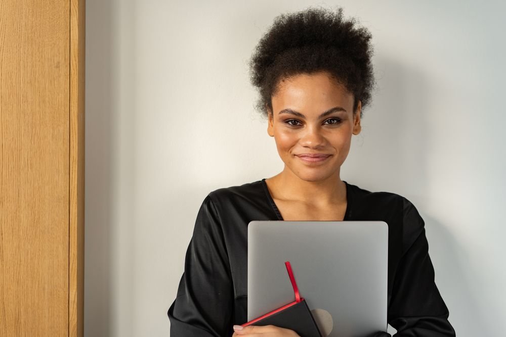 Portrait of a smiling professional holding a laptop