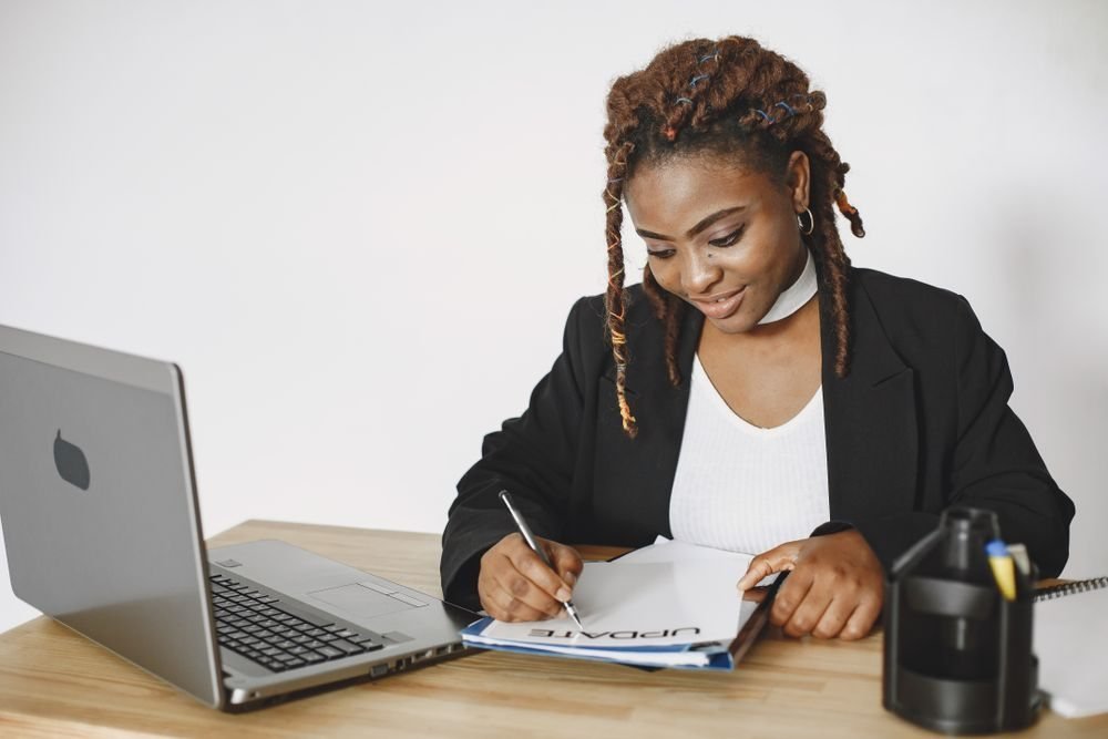 Founder writing notes at her laptop