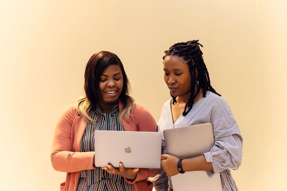 Two colleagues reviewing work on a laptop