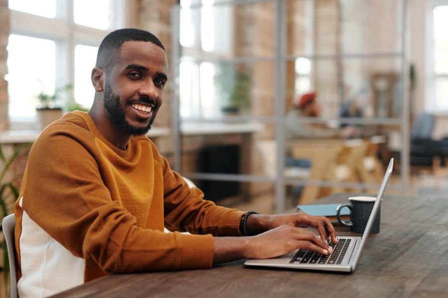 Smiling entrepreneur working on his laptop